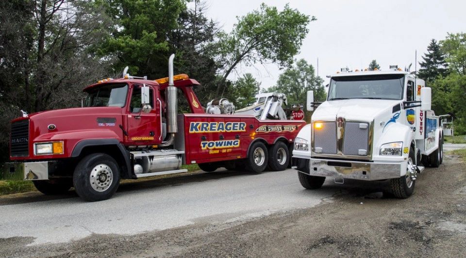 Two Kreager towing trucks side by side